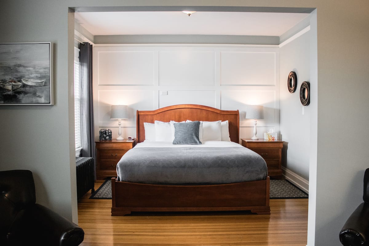 A neatly arranged bedroom with a wooden bed, bedside tables, and a nightstand.