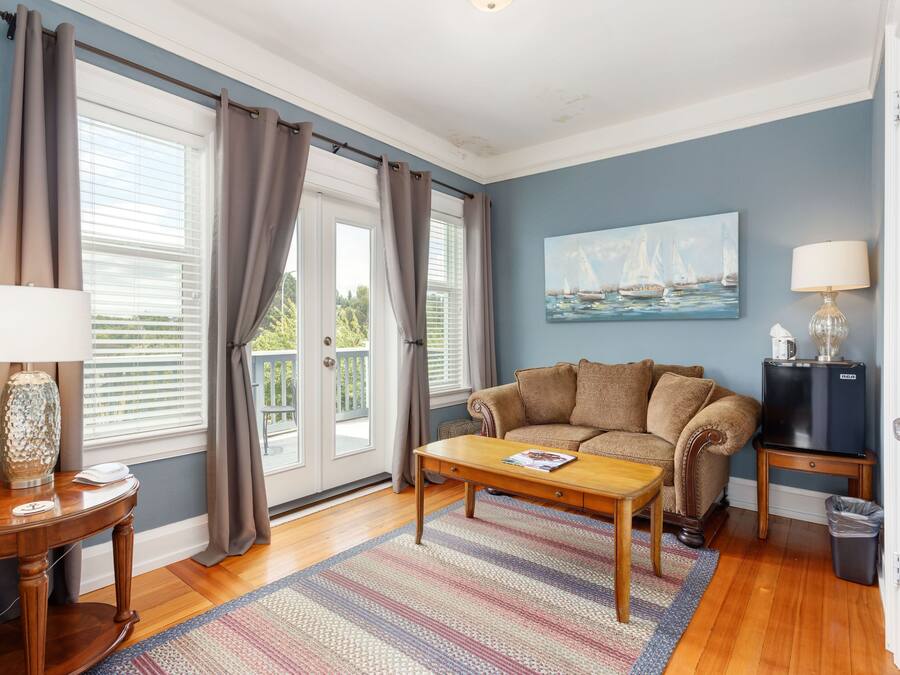 A living room with a sofa, coffee table, and a painting on the wall.