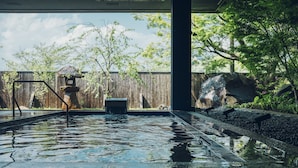 A swimming pool with a wooden fence and trees in the background.