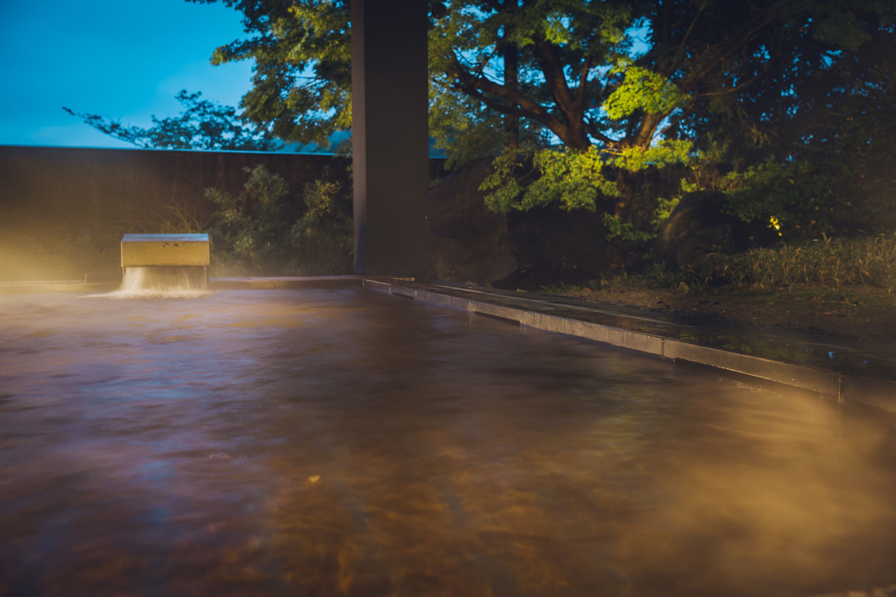 Un área de spa con un jacuzzi y un banco de piedra.