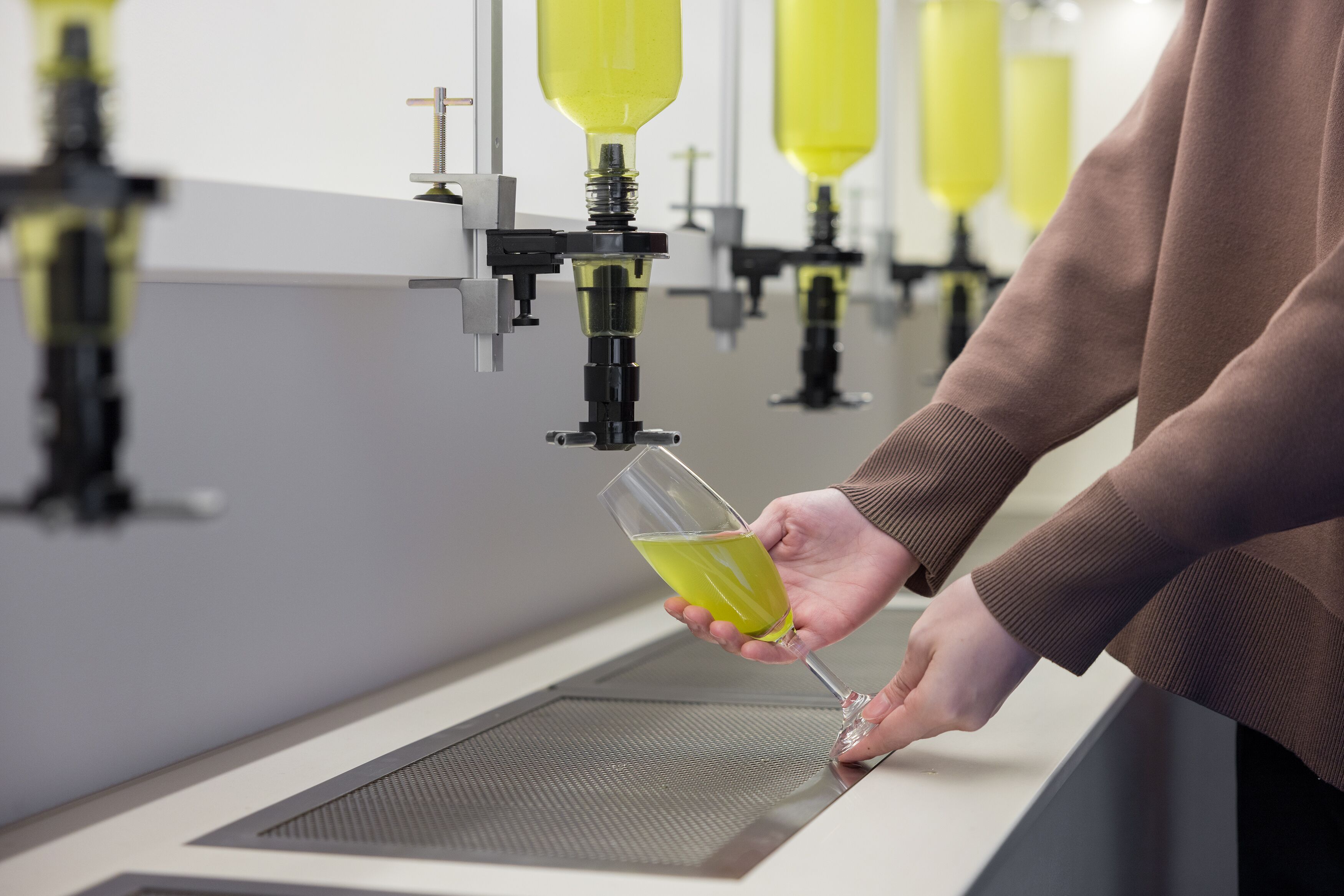 Une personne verse un liquide jaune dans un verre.