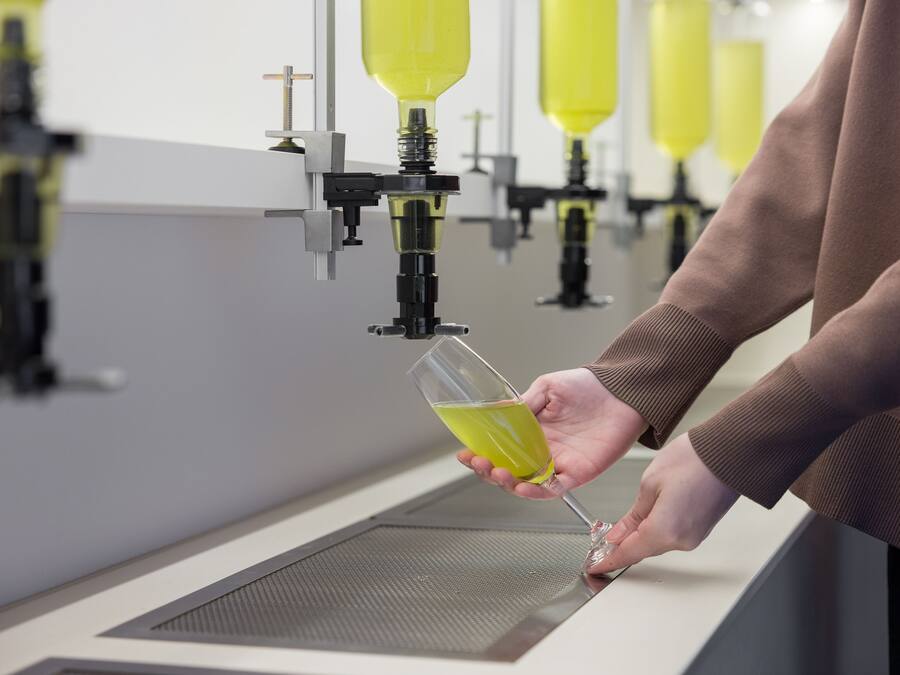 Une personne verse un liquide jaune dans un verre.
