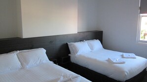 Two single beds with white linens in a hotel room. - Queens Head Hotel (North Hobart)