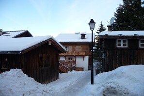 A wooden building with a balcony and a snow-covered roof. - Apartment in Le Village Complex, France (Notre Dame de Bellecombe)