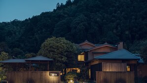 Un edificio tradicional japonés con fachada de madera, varios niveles y un porche cubierto.