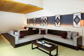 Ein modernes Wohnzimmer mit einer Eckcouch, einem Couchtisch und dekorativen Wandpaneelen.
