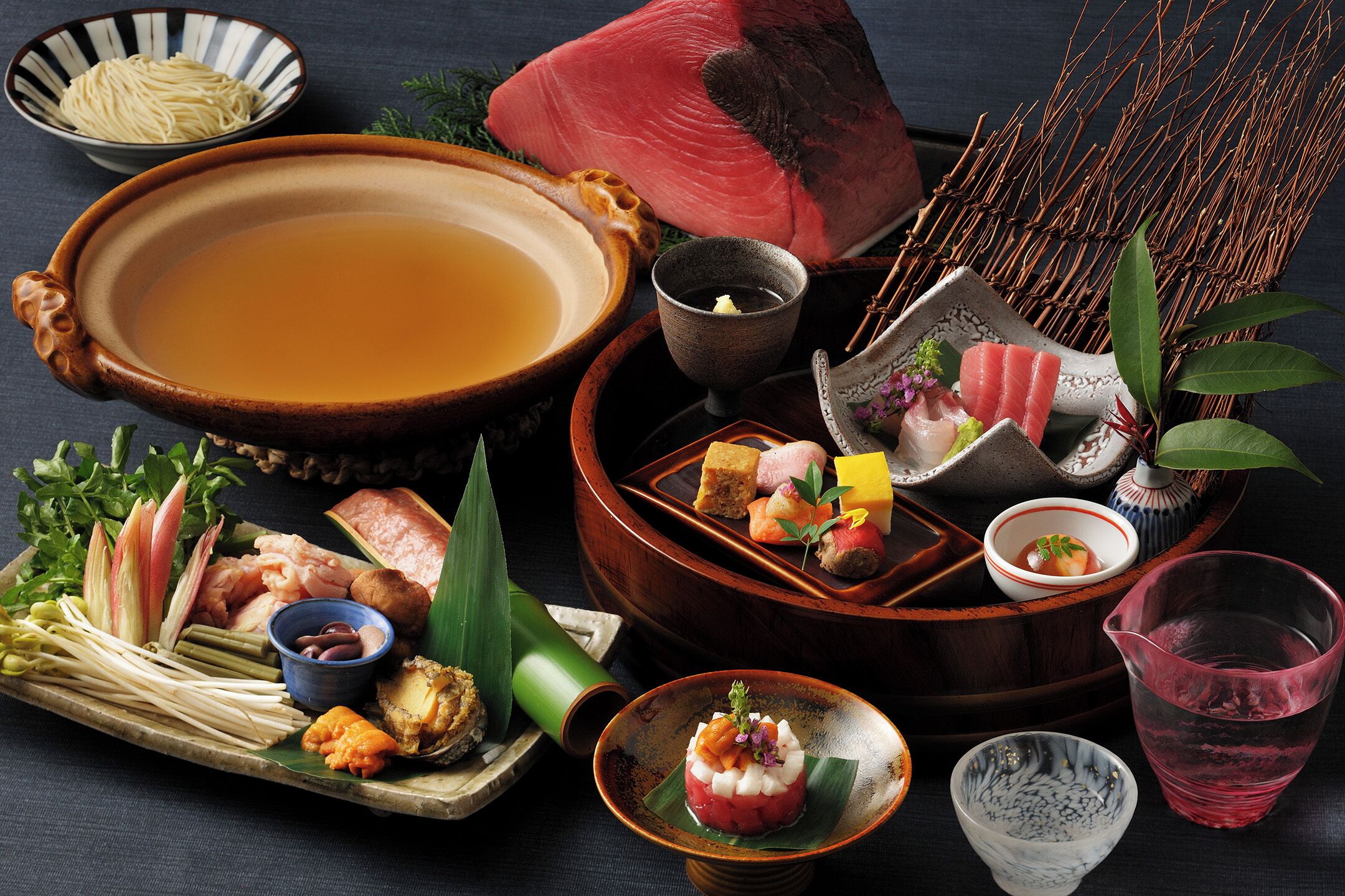 A traditional Japanese meal setup with various dishes and a large bowl of soup.