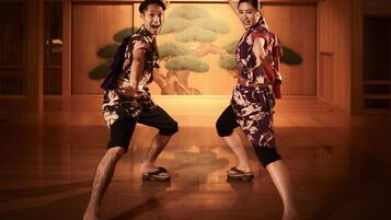 Two people in a room with wooden floors and a mural of trees.