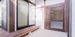 Un banco de madera frente a un edificio con grandes puertas y ventanas de vidrio.