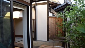 Une terrasse en bois avec une porte-fenêtre coulissante donnant sur une pièce.