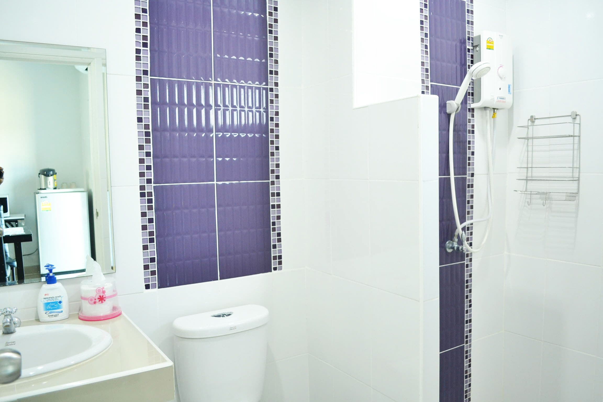 A bathroom with a white sink, a toilet, and a shower area.