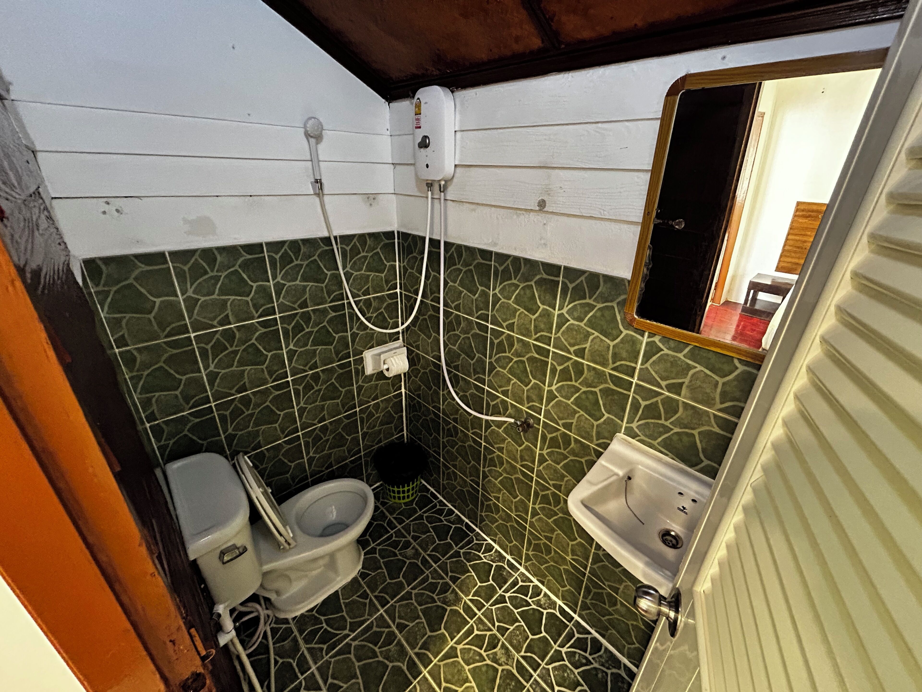 A compact bathroom with a toilet, sink, and shower.