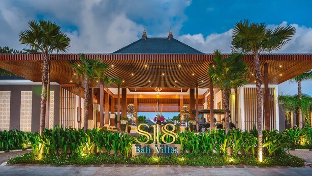 Una villa moderna con entrada cubierta, palmeras y un letrero que dice "S18 Bali Villas".