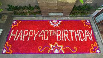Una alfombra roja con la inscripción 'HAPPY 40TH BIRTHDAY' en letras blancas, rodeada de llamativos diseños florales.