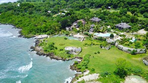 An aerial view of a coastal resort with multiple buildings, a swimming pool, and lush greenery. - Tanna Evergreen Resort & Tours (Tanna Island)