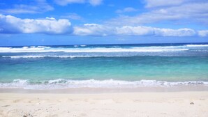 A beach with clear turquoise water and a sandy shore under a partly cloudy sky. - Tanna Evergreen Resort & Tours (Tanna Island)