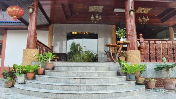 Un edificio tradicional de madera con una escalera de piedra que lleva a una puerta.