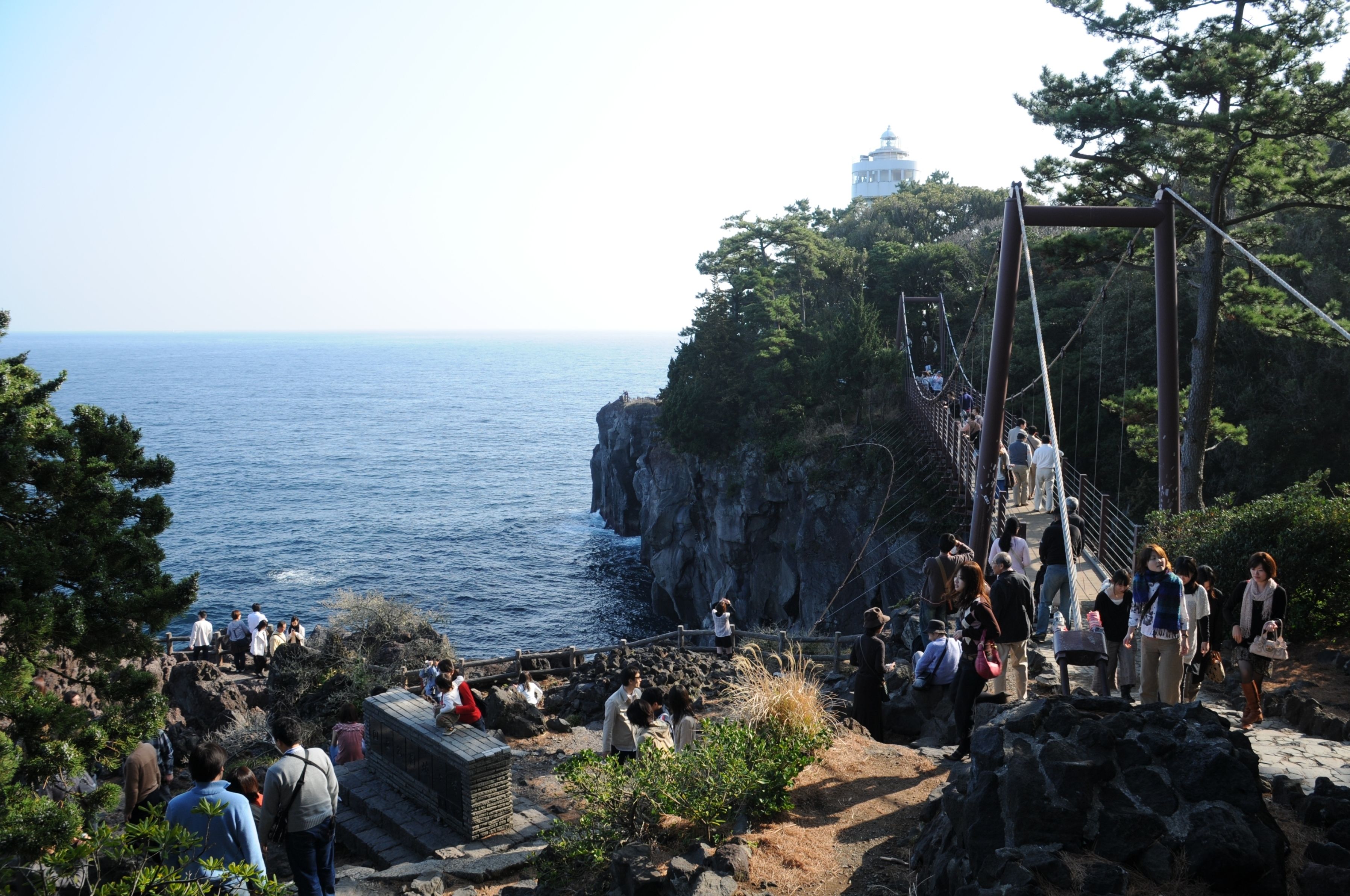 A coastal area with a rocky path leading to a viewpoint overlooking the sea.