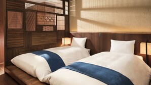 A room with two beds, wooden headboard, and a window with a view. - Hoshino Resorts KAI Anjin (Ito)