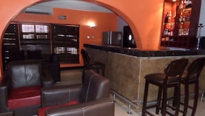 Eine Bar mit Ledersitzmöbeln und einer Theke.