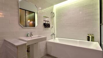 Un baño moderno con una bañera blanca, un lavabo y una ducha.
