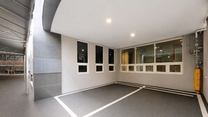 A spacious indoor area with a grey floor, white walls, and multiple windows. - February Hotel Sungseo (Daegu)