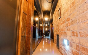 A corridor with a polished floor, wooden paneling on one side, and a brick wall on the other. - February Hotel Sungseo (Daegu)