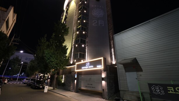 A hotel with a modern design, featuring a prominent sign with the name and a large number indicating the floor. - February Hotel Sungseo (Daegu)