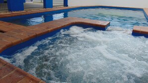 A swimming pool with a brick edge and a blue and white wall surrounding it. - Rockhampton Court Motor Inn (Rockhampton)