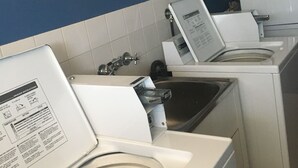 A laundry area with white washing machines and a sink. - Rockhampton Court Motor Inn (Rockhampton)