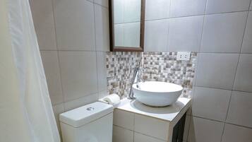 A bathroom with a toilet, sink, and shower curtain.