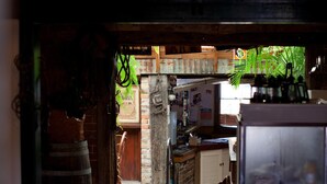 A narrow hallway with wooden flooring, a ceiling fan, and a refrigerator stocked with beverages.
