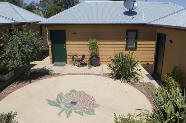 A building with a green door, a small window, and a satellite dish on the roof. - Prince of Wales Motel (Gulgong)