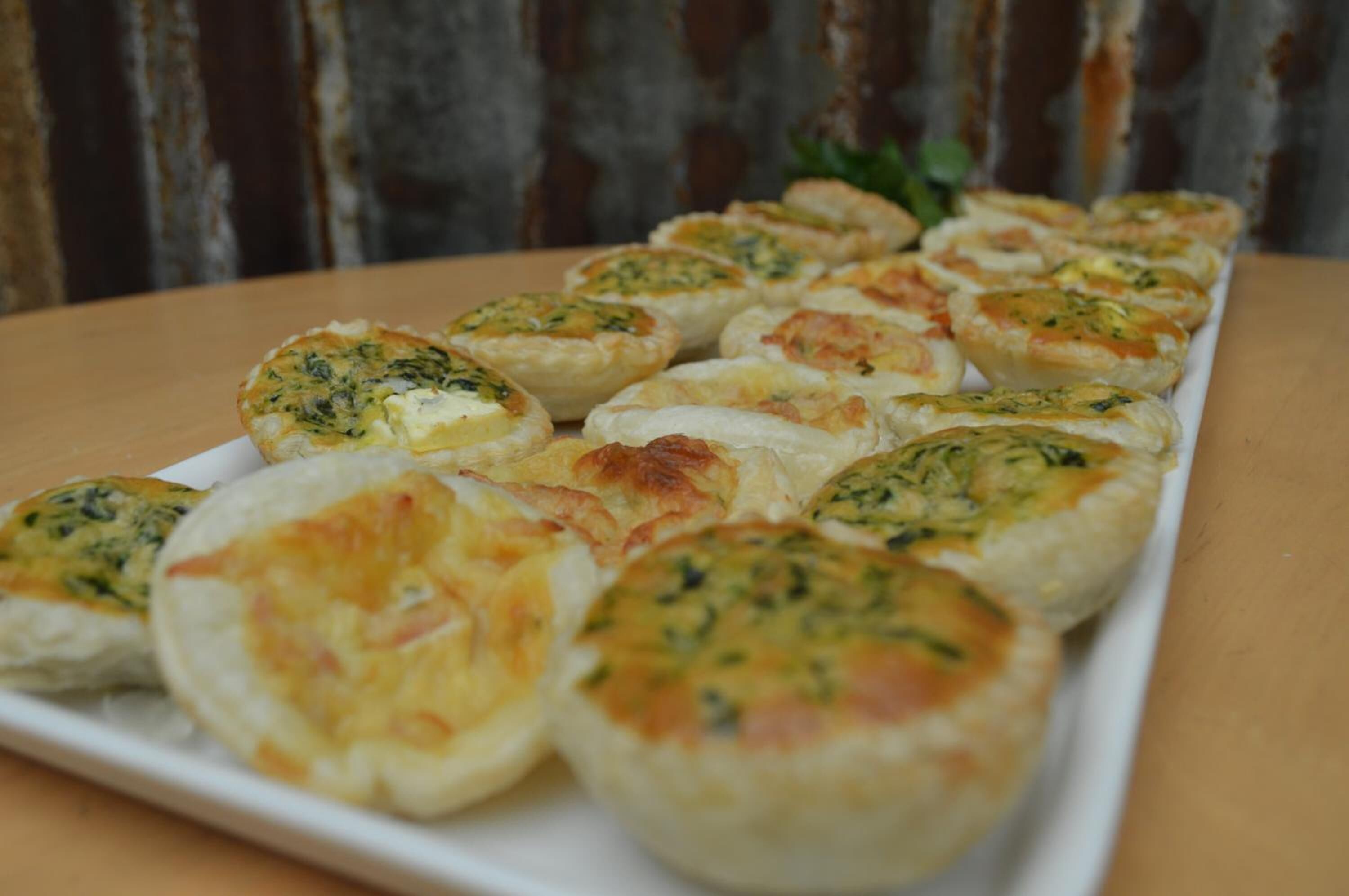 A plate of baked pastries with herbs and cheese.