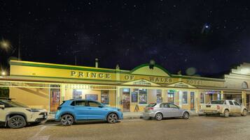 The exterior of the Prince of Wales Hotel with a clear view of the entrance, signage, and parked cars.