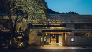 A modern building with a brick facade, a large tree in the foreground, and a well-lit entrance. - Hoshino Resorts KAI Hakone (Hakone)