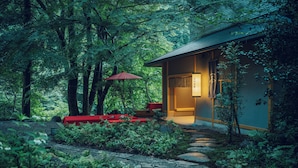 A traditional Japanese-style building with a stone pathway leading to a red bench and an umbrella. - Hoshino Resorts KAI Hakone (Hakone)