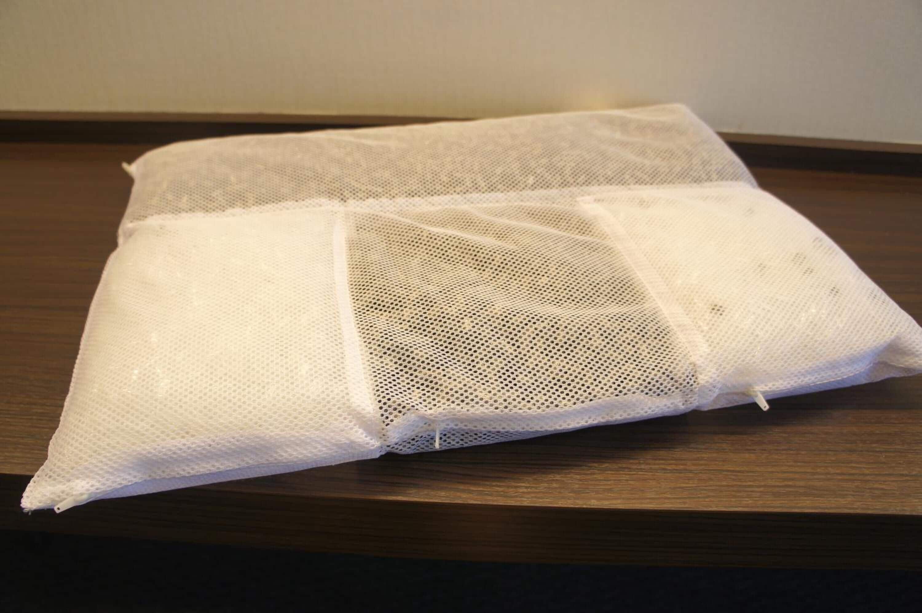 A white mesh bag on a wooden surface.