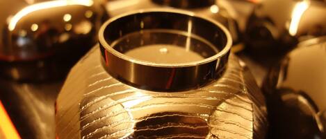 A close-up of a metallic container with a reflective surface, surrounded by other similar containers.