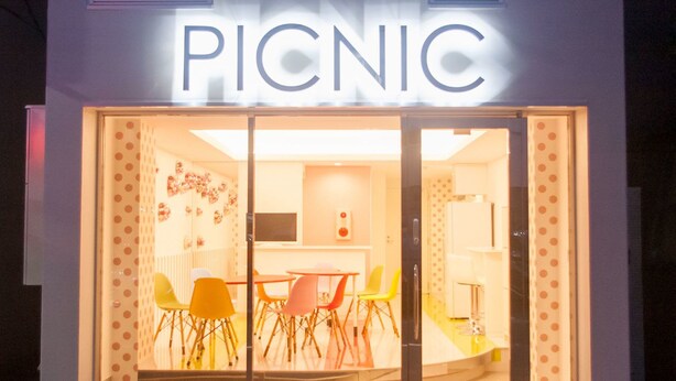 A restaurant named "PICNIC" with a glass entrance, visible interior seating, and a modern design. - Picnic Hostel Osaka (Osaka)