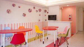 A children's playroom with colorful chairs and tables, a television, and decorative wall art. - Picnic Hostel Osaka (Osaka)