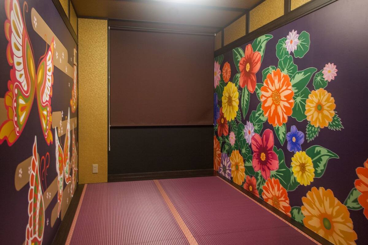 A hallway with vibrant floral murals on the walls and a patterned floor.