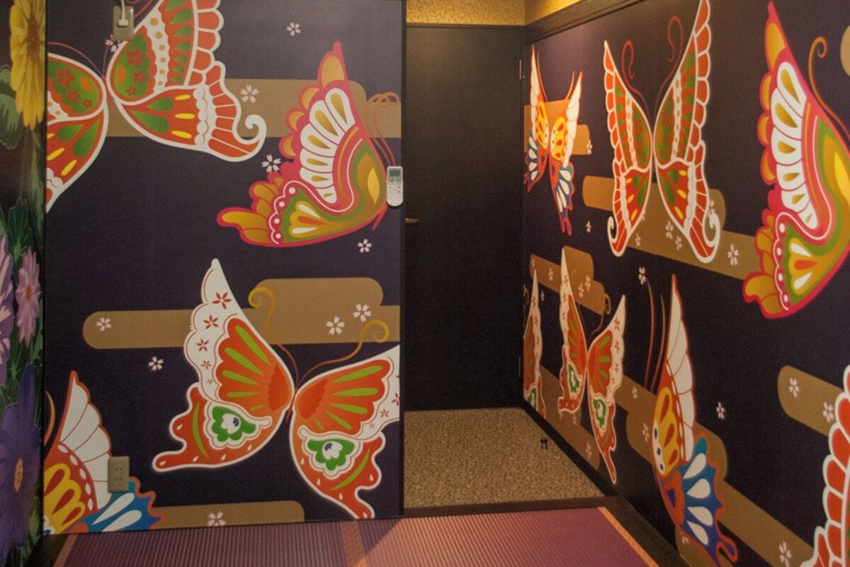 A hallway with colorful butterfly murals on the walls and a red carpet.
