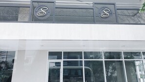 A building with a large glass facade and two prominent 'S' signs above the entrance. - Solemare Parksuites Condo R Us (Parañaque)
