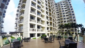 A multi-story hotel with outdoor seating areas and balconies. - Solemare Parksuites Condo R Us (Parañaque)