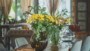 Un coin repas avec une table en bois, des chaises et un lustre.