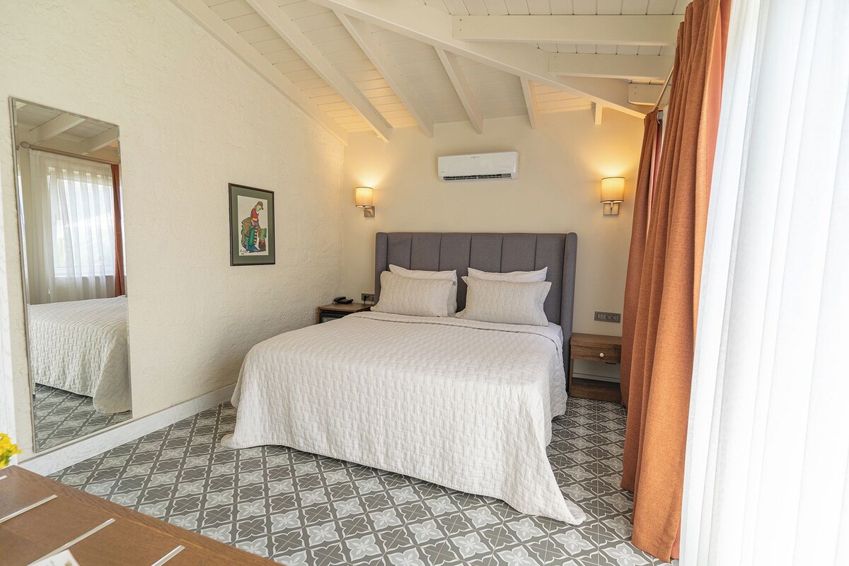 Un dormitorio con cama, mesita de noche, espejo, equipo de aire acondicionado y piso estampado.