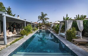 A swimming pool with lounge chairs and a covered seating area. - Casa Luna Hotel Alaçati (Cesme)