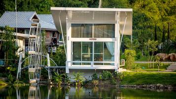 Situated by the water, this single-story building offers a tranquil retreat with large windows and a garden.