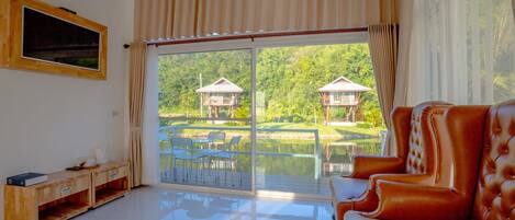 A spacious living room with a large sliding glass door leading to a scenic outdoor area.